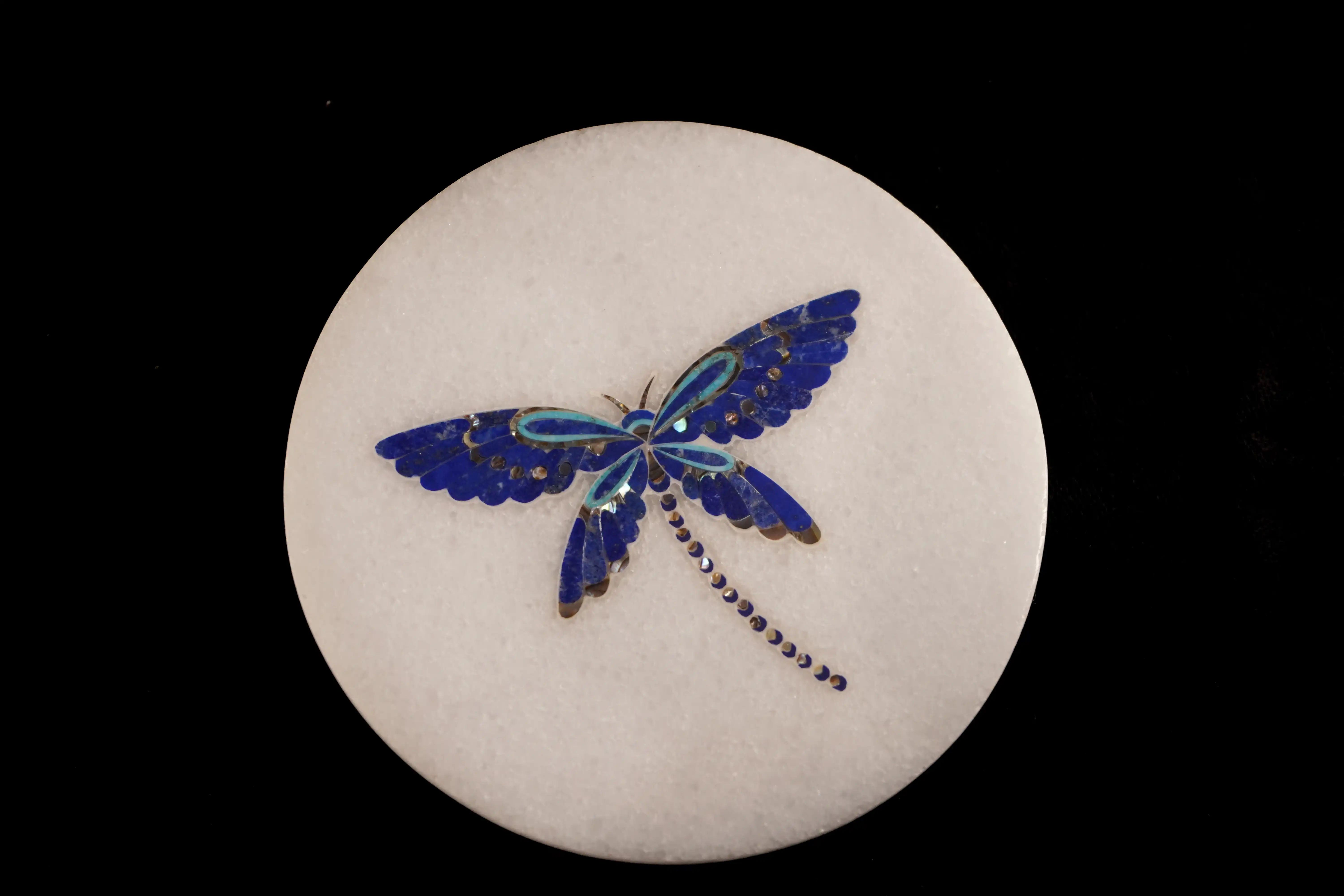 Dragonfly with blue stone inlay on a white marble base.